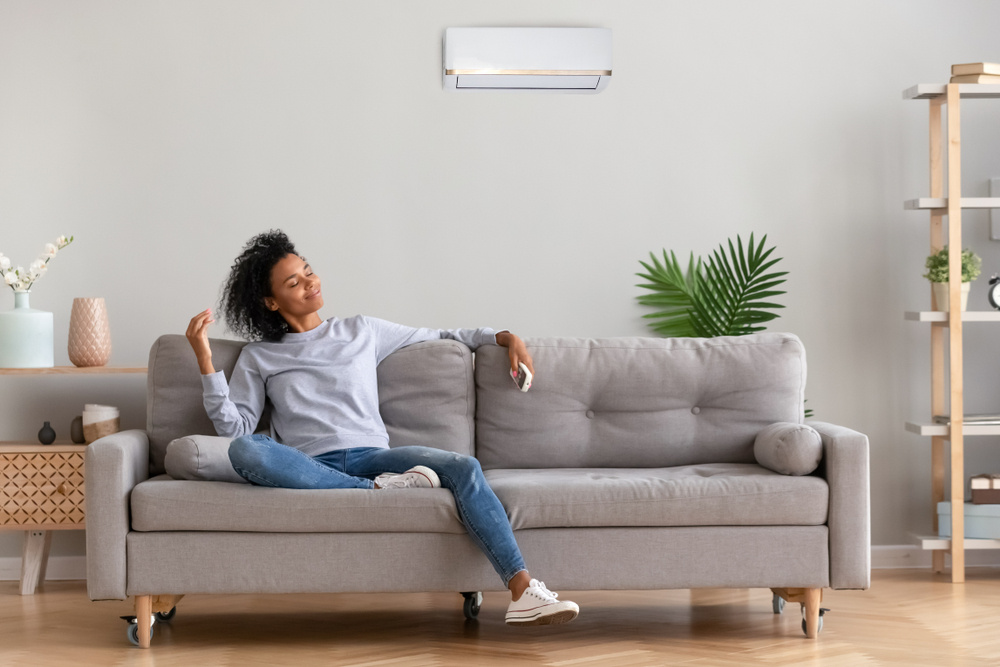 African,american,relaxed,woman,sitting,on,comfortable,couch,in,living